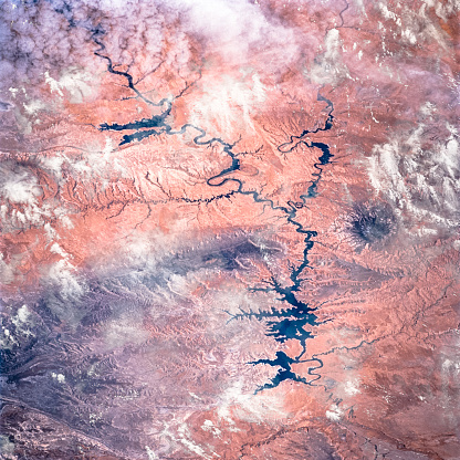 The Colorado River through the clouds and arid terrain of southeastern Utah, satellite view. Elements of this image furnished by NASA.
