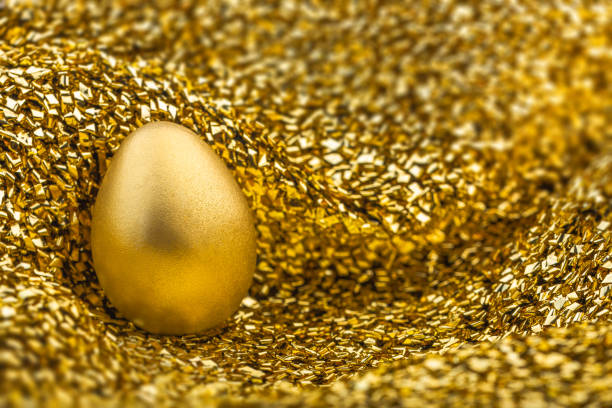 istock Image of shiny golden egg on golden fabric 1129396571
