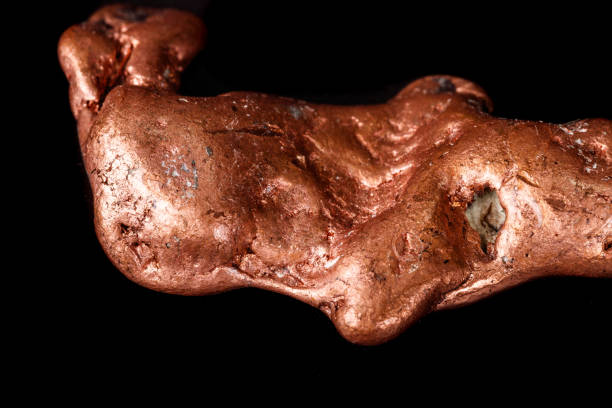 istock Macro mineral stone of a copper nugget on a microcline on a black background 1129396705
