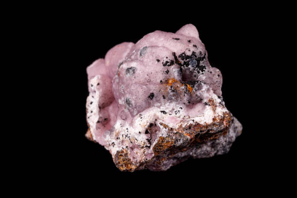 Macro pink Smithsonite mineral stone on microcline on black background close up