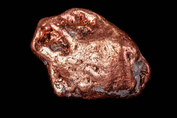 Macro mineral stone of a copper nugget on a microcline on a black background