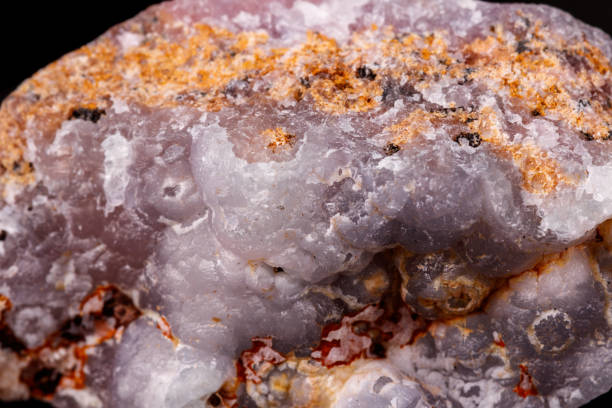 istock Macro pink Smithsonite mineral stone on microcline on black background 1129398067