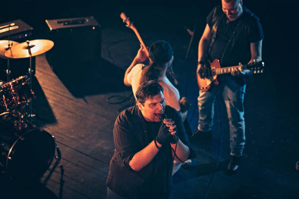 istock Rock and roll band performing hard rock music on stage 1129399116