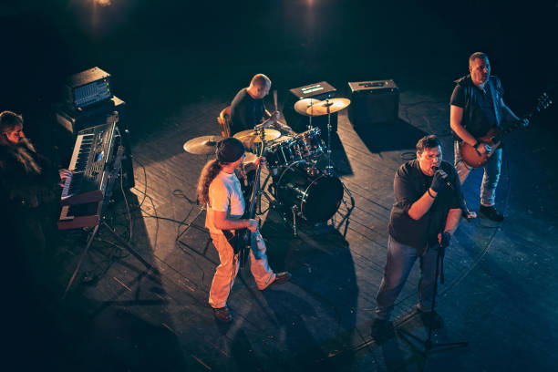 istock Rock and roll band performing hard rock music on stage 1129401517
