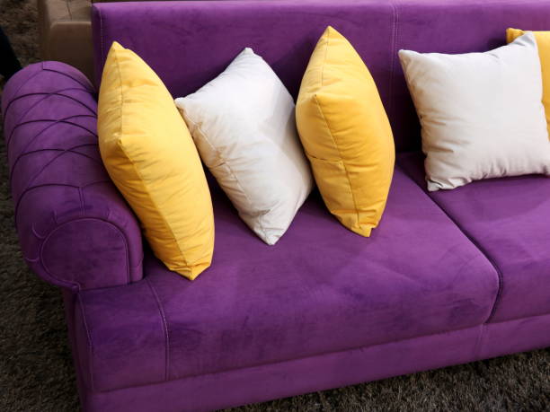 黄色と白の枕で紫二人乗り - two seater sofa ストックフォトと画像