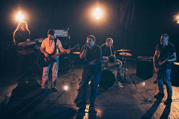 istock Rock and roll band performing hard rock music on stage 1129401804