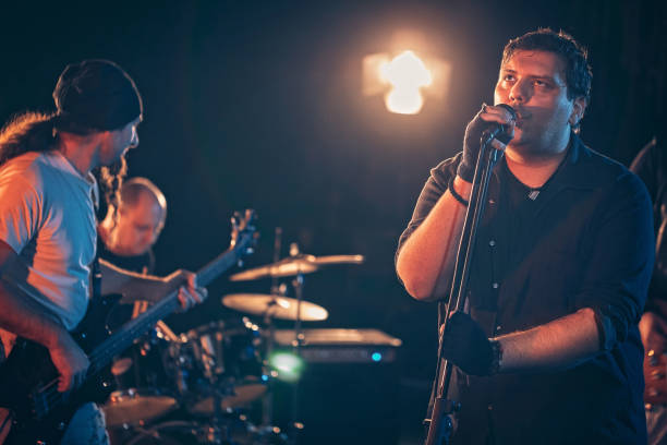 istock Rock and roll band performing hard rock music on stage 1129402258