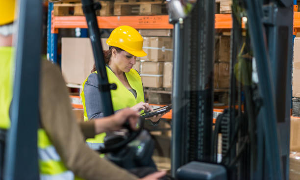istock Female Warehouse Supervisor Writing On Digital Tablet While Standing In Warehouse 1129403780