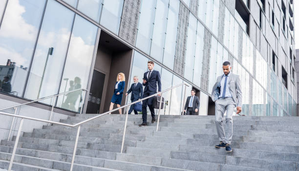istock Business People Walking Down the Stairs 1129404117