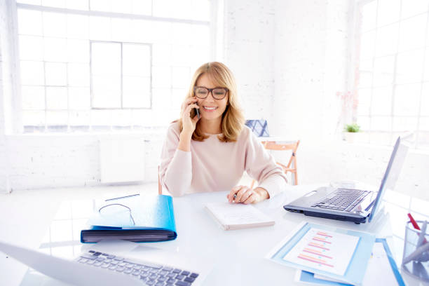 istock Businesswoman making a call while working on laptop in the office 1129406847