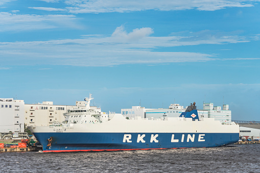 TOKYO, JAPAN - August 24 2018: Giant cargo ship Shurei II from RKK LINE with the flag of Japan moored in the commercial port of Tokyo Bay.