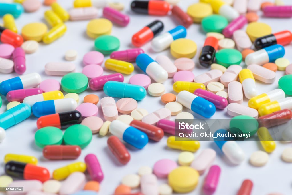 Medicine green and yellow pills or capsules on a white background with copy space. Medicine Stock Photo