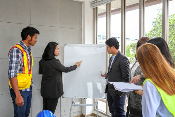 istock Engineers are meeting on the whiteboard. Blueprint Interior Design structure and development. contractor presentation for team and client in the office. Asian people. 1129413088