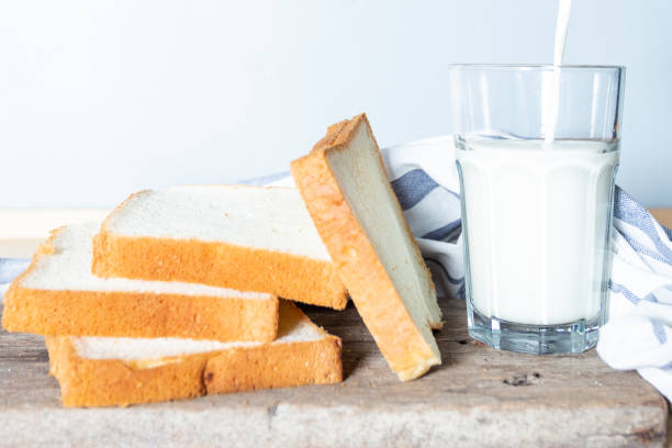 istock Pour the milk into the glass and the bread. Simple breakfast 1129413316