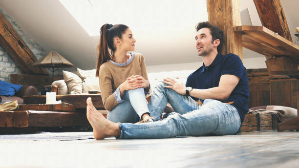 istock happy couple talking to each other at home 1129414536