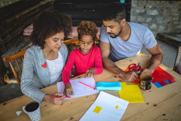 Two parents helping their daughter with homework