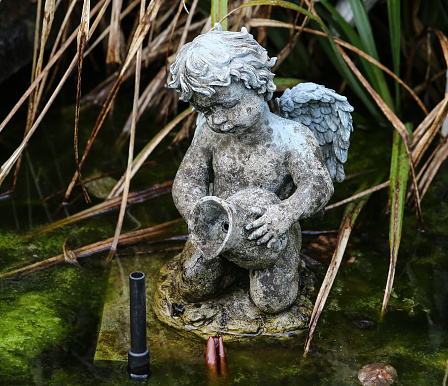 Statue of a child angel made of light stone.