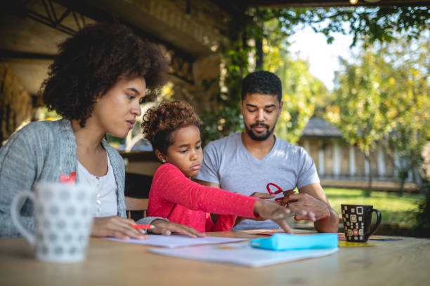 istock Cute child doing homework with the parents 1129415069