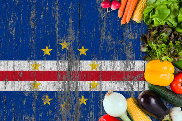 istock Fresh vegetables from Cape Verde on table. Cooking concept on wooden flag background. 1129417321