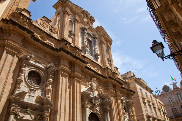 trapani sicile scène montrant la façade de l’église du collège des jésuites dans le centre historique de trapani et le palais cavarretta à la fin de la rue. - trapani photos et images de collection