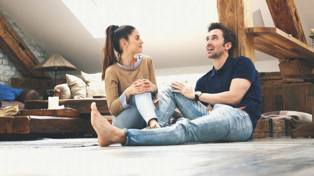 istock happy couple talking to each other at home 1129419577