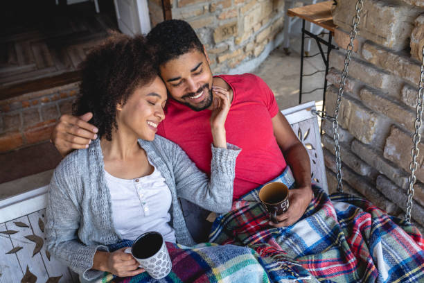 istock Affectionate couple drinking tea on a porch swing 1129419600
