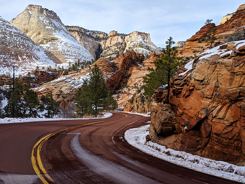 Melting snow and icicles on red rock cliffs along the scenic road near Checkerboard Mesa in Zion National Park Utah