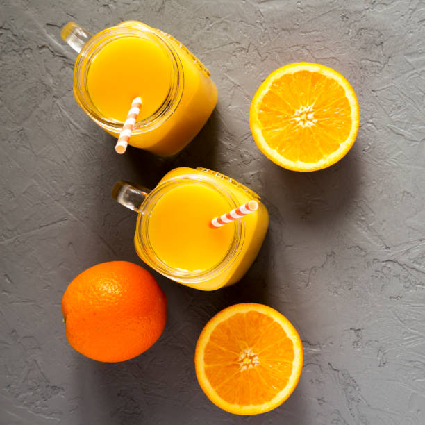 istock Fresh orange juice in glass jars, top view. From above, overhead. 1129421410
