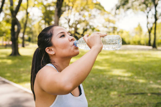 istock Young woman drinking water during workout 1129424020