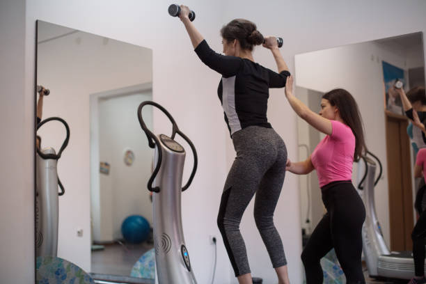 istock Woman exercising with personal trainer 1129425602