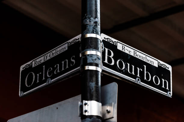 istock Orleans and Bourbon Streets Sign intersection text in New Orleans on lamp pole post at night isolated closeup 1129425735
