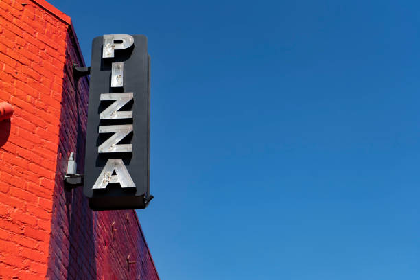 istock Broken neon Pizza sign on red brick wall 1129425975