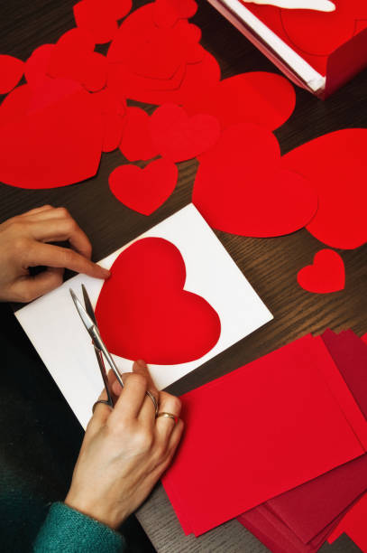 istock Woman doing Valentine's day paper cut-outs 1129426665