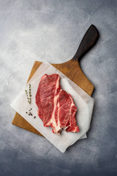 istock Fresh beef at wood board on gray background 1129427534