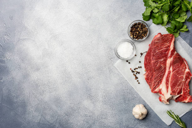 istock Frame with fresh beef and herbs, condiments and garlic at gray background 1129427589