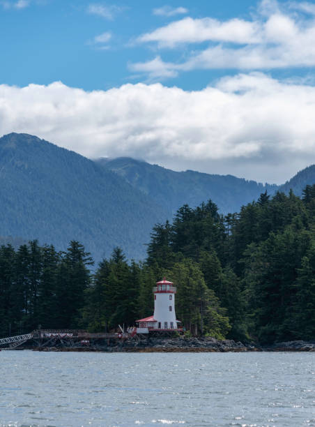 istock Lighthouse and mountains on a sunny day 1129427869