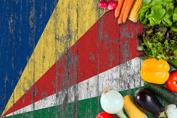 istock Fresh vegetables from Seychelles on table. Cooking concept on wooden flag background. 1129431812