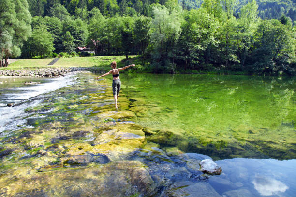 young woman walking across kupa river - river kolpa imagens e fotografias de stock