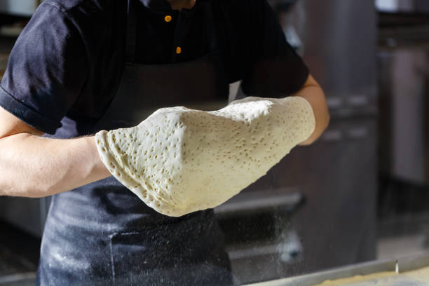 istock Baker makes the pizza base at a fast food restaurant 1129438841