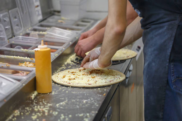 istock Men make different pizzas in the fast food restaurant 1129438843