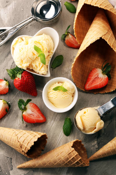 istock Vanilla ice cream scoop with fresh strawberries and icecream cones 1129440504