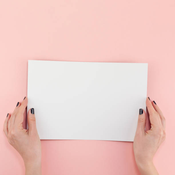 istock Woman hands with blank A4 paper sheet mockup 1129440944