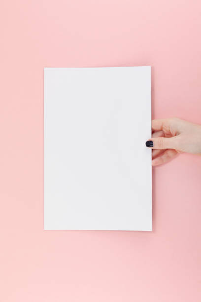 istock Woman hands with blank A4 paper sheet mockup 1129440950
