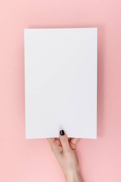istock Woman hands with blank A4 paper sheet mockup 1129440967