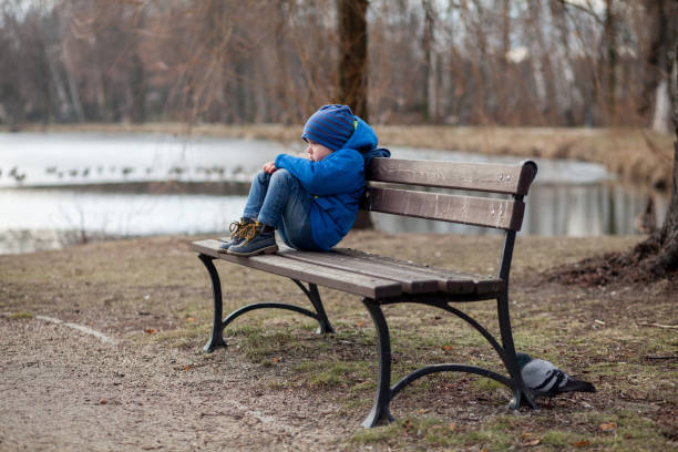 A child with depression on a park bench