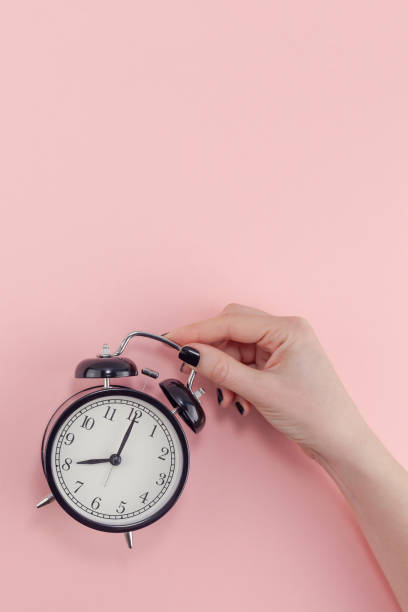 istock Female hand with alarm clock. Morning concept 1129441201