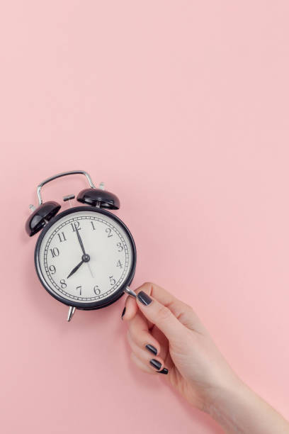istock Female hand with alarm clock. Morning concept 1129441217