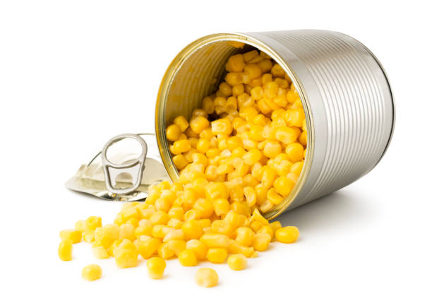 istock Corn was poured out with an open metal can on a white background. 1129445496