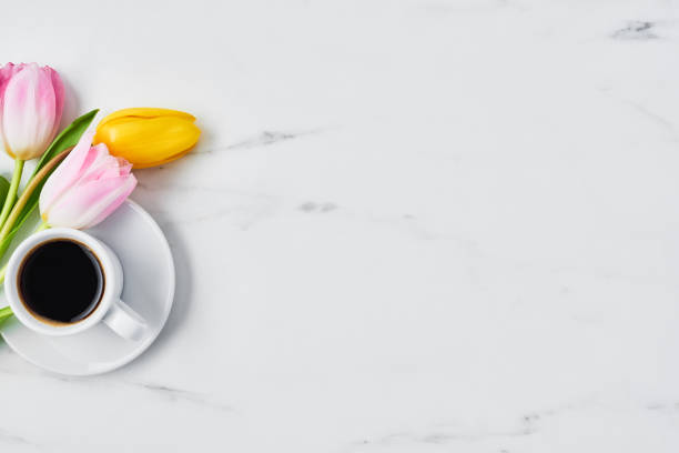 istock Cup of coffee with tulips 1129452046