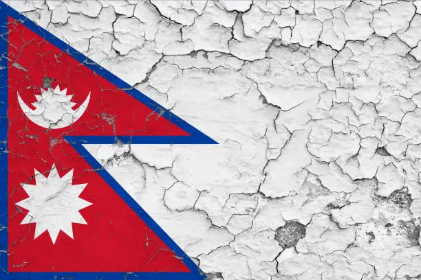 Photo of Flag of Nepal painted on cracked dirty wall. National pattern on vintage style surface.